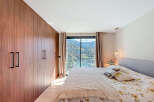 This stunning bedroom boasts a modern design with a large wardrobe and a breathtaking mountain view.