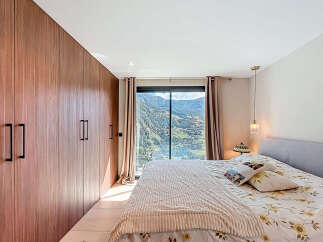 This stunning bedroom boasts a modern design with a large wardrobe and a breathtaking mountain view.