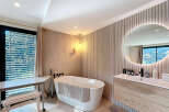 Experience luxury in this stunning bathroom, featuring a modern freestanding tub and a stylish vanity.