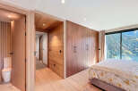 Experience luxury living in this stunning bedroom featuring exquisite wooden accents and a breathtaking mountain view.