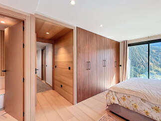 Experience luxury living in this stunning bedroom featuring exquisite wooden accents and a breathtaking mountain view.