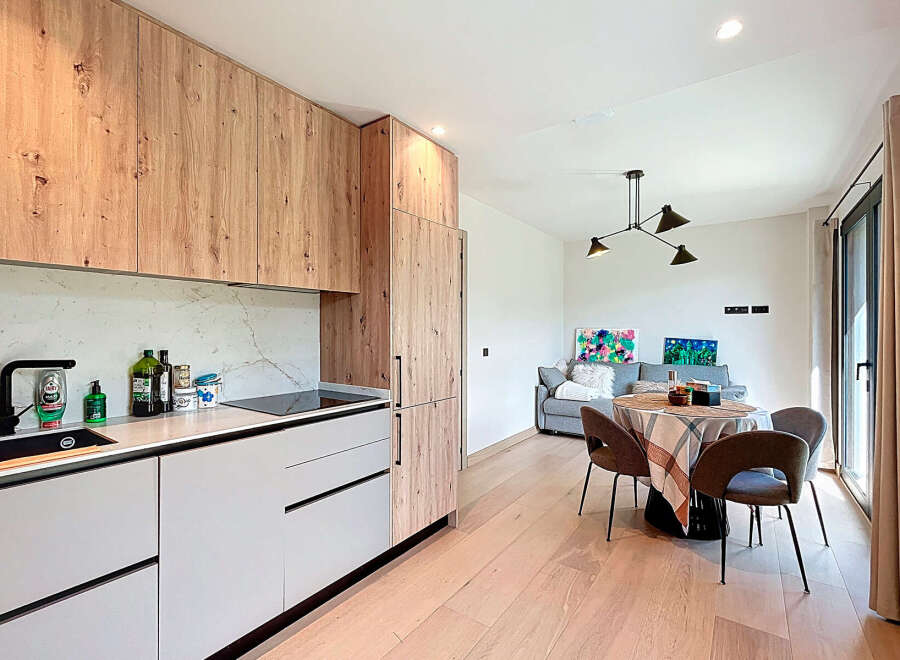 This modern kitchen boasts sleek cabinetry and a marble backsplash, creating a stylish and functional space.
