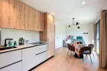 This modern kitchen boasts sleek cabinetry and a marble backsplash, creating a stylish and functional space.