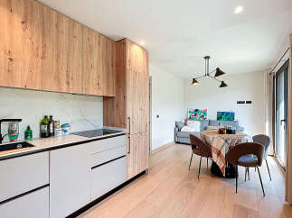 This modern kitchen boasts sleek cabinetry and a marble backsplash, creating a stylish and functional space.