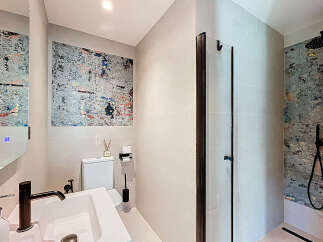 Step into a modern bathroom oasis! This stylish space features a sleek sink, a contemporary shower, and an eye-catching accent wall.