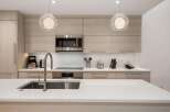 This modern kitchen boasts sleek design and high-end appliances, perfect for culinary enthusiasts.