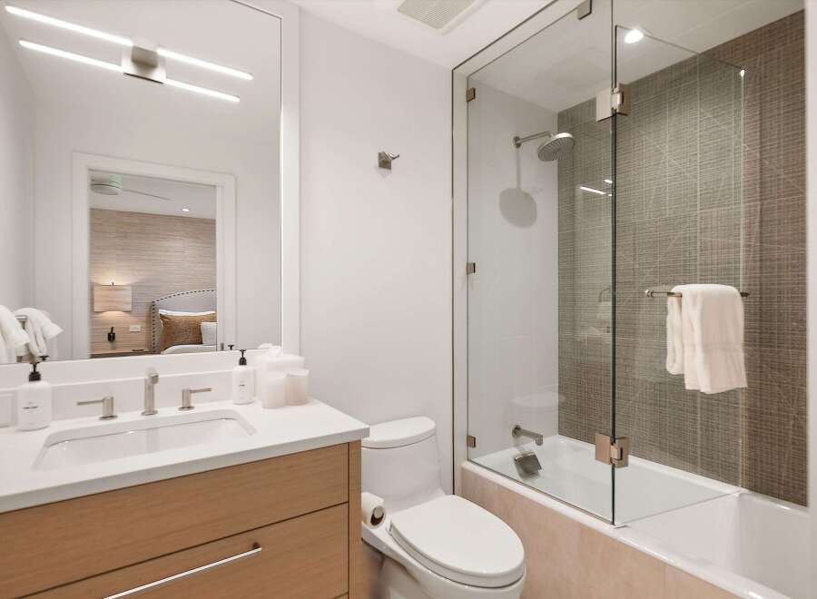 Step into luxury with this stunning bathroom, featuring a sleek glass shower enclosure and modern fixtures.