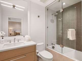 Step into luxury with this stunning bathroom, featuring a sleek glass shower enclosure and modern fixtures.