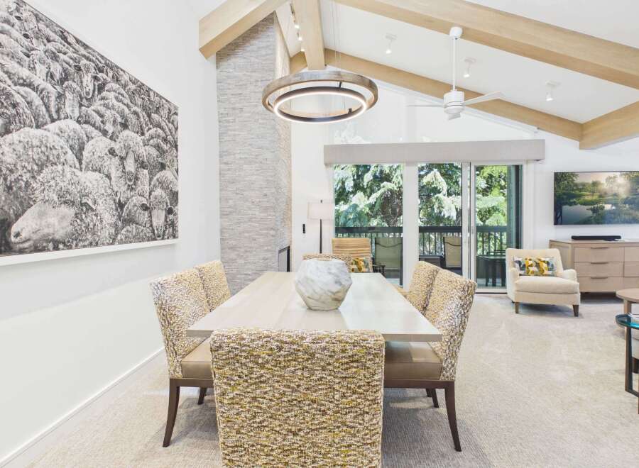 Experience luxury living in this stunning dining area, featuring a large abstract sheep artwork and a modern stone fireplace.