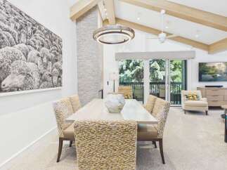 Experience luxury living in this stunning dining area, featuring a large abstract sheep artwork and a modern stone fireplace.