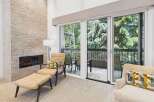 Experience modern living with this stunning living room featuring a sleek, stacked stone fireplace and expansive sliding glass doors that open to a private balcony.