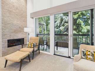 Experience modern living with this stunning living room featuring a sleek, stacked stone fireplace and expansive sliding glass doors that open to a private balcony.