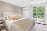 Experience ultimate comfort in this luxurious bedroom featuring a plush king-sized bed with a tufted headboard and elegant gold accent pillows.