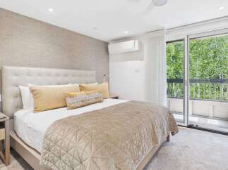 Experience ultimate comfort in this luxurious bedroom featuring a plush king-sized bed with a tufted headboard and elegant gold accent pillows.