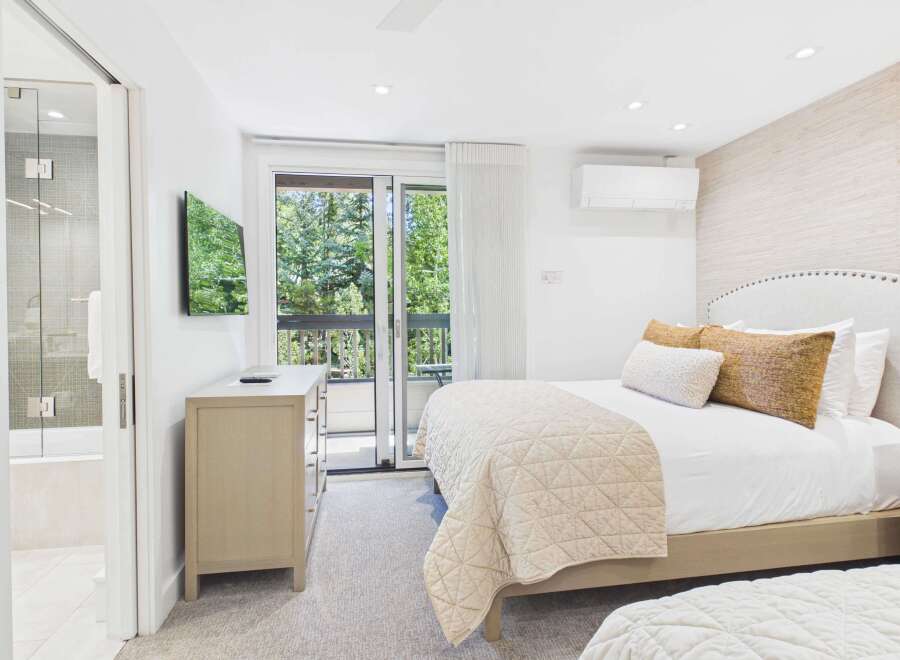 Experience ultimate comfort in this beautifully appointed bedroom featuring a plush king-sized bed adorned with luxurious linens and decorative pillows.