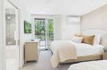 Experience ultimate comfort in this beautifully appointed bedroom featuring a plush king-sized bed adorned with luxurious linens and decorative pillows.