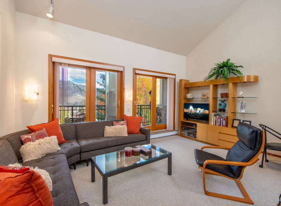 Experience luxury living in this stunning property, featuring a spacious living room with a modern sectional sofa and a glass-top coffee table.
