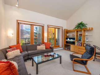 Experience luxury living in this stunning property, featuring a spacious living room with a modern sectional sofa and a glass-top coffee table.