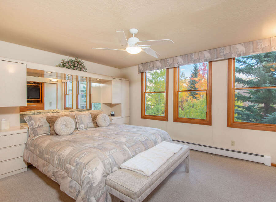 This beautiful bedroom offers a serene retreat with its neutral color palette and ample natural light.