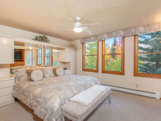 This beautiful bedroom offers a serene retreat with its neutral color palette and ample natural light.