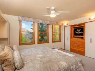This inviting bedroom showcases a cozy atmosphere with its comfortable bed and scenic views.