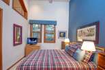 This cozy bedroom features a comfortable plaid bed, perfect for relaxing after a long day.