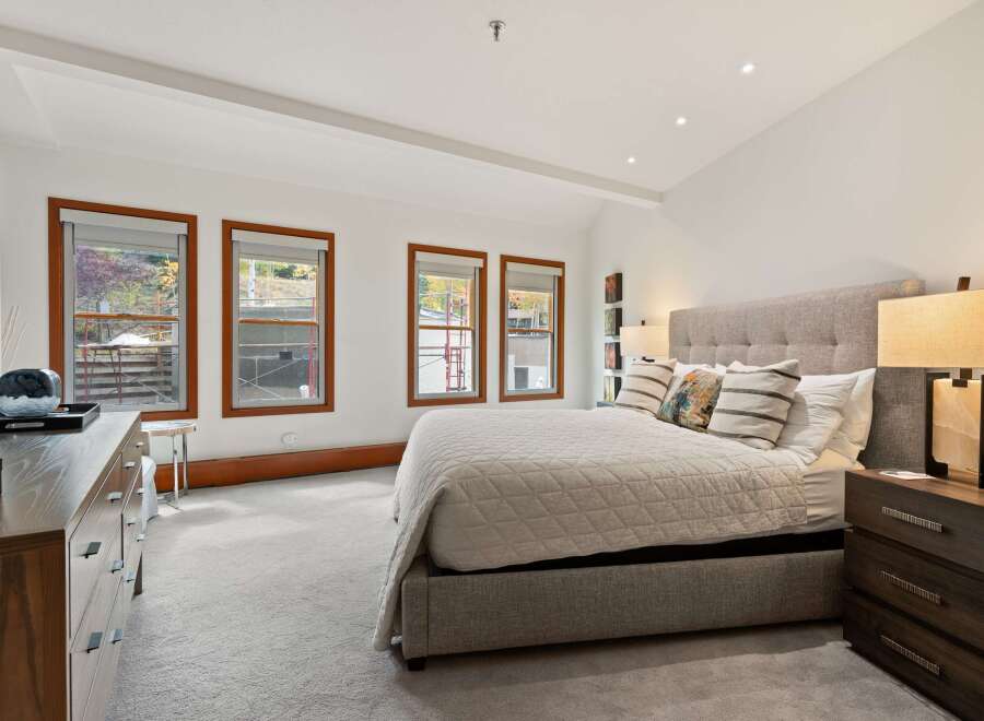 This stunning bedroom boasts a modern design with a neutral color palette, creating a serene and inviting atmosphere.