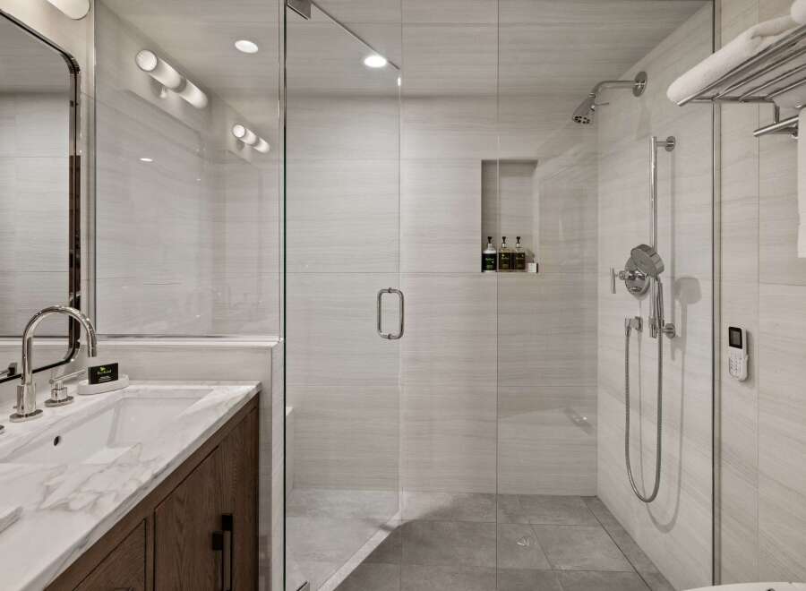 Step into luxury with this stunning bathroom featuring a modern glass-enclosed shower and elegant marble countertops.