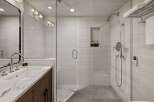 Step into luxury with this stunning bathroom featuring a modern glass-enclosed shower and elegant marble countertops.