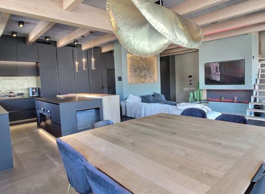 Experience modern luxury in this stunning property, featuring a sleek kitchen with a central island and state-of-the-art appliances.