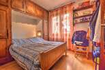 Discover the charm of this cozy bedroom, featuring a built-in wooden bed frame and ample storage cabinets.