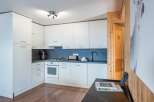 This modern kitchen features sleek white cabinetry and a dark countertop, creating a clean and stylish look.