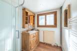 Discover the charm of this beautifully designed bathroom, featuring a rustic wooden vanity and a stylish shower enclosure.