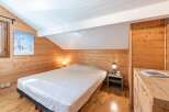 This cozy bedroom features beautiful wooden paneling and a comfortable bed, creating a warm and inviting atmosphere.