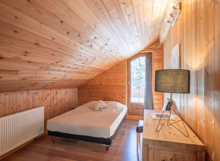 This cozy bedroom features a warm wooden interior, creating a rustic and inviting atmosphere.