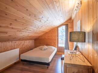 This cozy bedroom features a warm wooden interior, creating a rustic and inviting atmosphere.