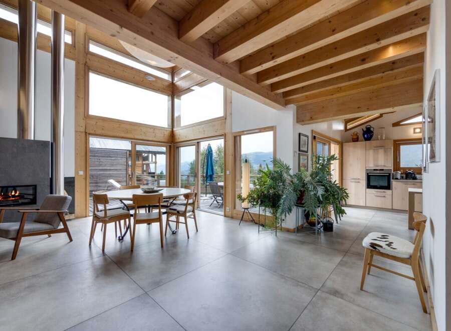 This stunning property boasts a modern open-plan living space with a cozy fireplace and expansive windows that flood the interior with natural light.