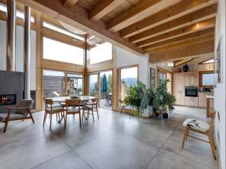This stunning property boasts a modern open-plan living space with a cozy fireplace and expansive windows that flood the interior with natural light.