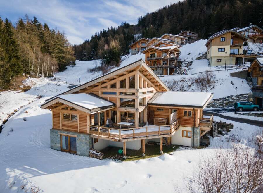Discover the epitome of mountain living in this stunning chalet nestled amidst a snowy landscape.