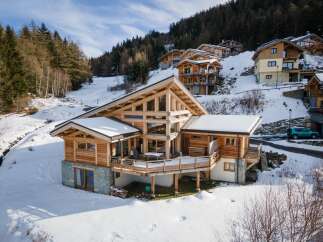 Discover the epitome of mountain living in this stunning chalet nestled amidst a snowy landscape.