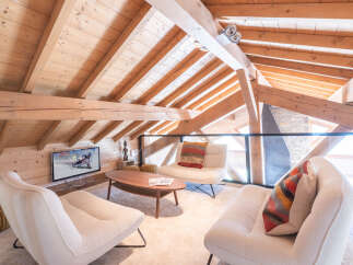 Discover the charm of this stunning property, featuring a cozy living area with a unique wooden ceiling and exposed beams.