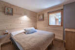 This cozy bedroom features beautiful wooden paneling and a comfortable bed, creating a warm and inviting atmosphere.