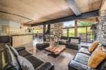 Experience luxury living in this stunning chalet, featuring a spacious living area with a cozy fireplace and comfortable seating.