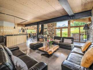 Experience luxury living in this stunning chalet, featuring a spacious living area with a cozy fireplace and comfortable seating.