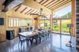 Experience luxury living in this stunning property, featuring a spacious dining area with a rustic wooden table and sleek metal chairs.
