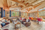 Experience luxury living in this stunning chalet, featuring a warm and inviting interior with exposed wooden beams and stone walls.