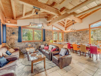 Experience luxury living in this stunning chalet, featuring a warm and inviting interior with exposed wooden beams and stone walls.