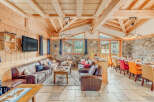 Experience the charm of this stunning chalet, featuring a cozy living area with comfortable leather sofas and a large TV.