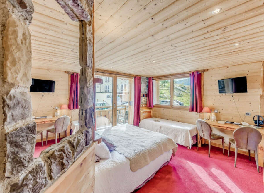 Experience the charm of this cozy bedroom featuring wooden walls and ceilings, creating a warm and inviting atmosphere.