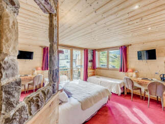 Experience the charm of this cozy bedroom featuring wooden walls and ceilings, creating a warm and inviting atmosphere.